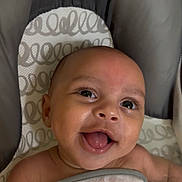 Onzai is registered to the contest to win money with this photo: baby, smiling, blanket, infant, happy, face, child, cute, cushion, eyes, mouth, tongue, skin, head, baby_seat, expression, closeup, indoors, joy, comfort