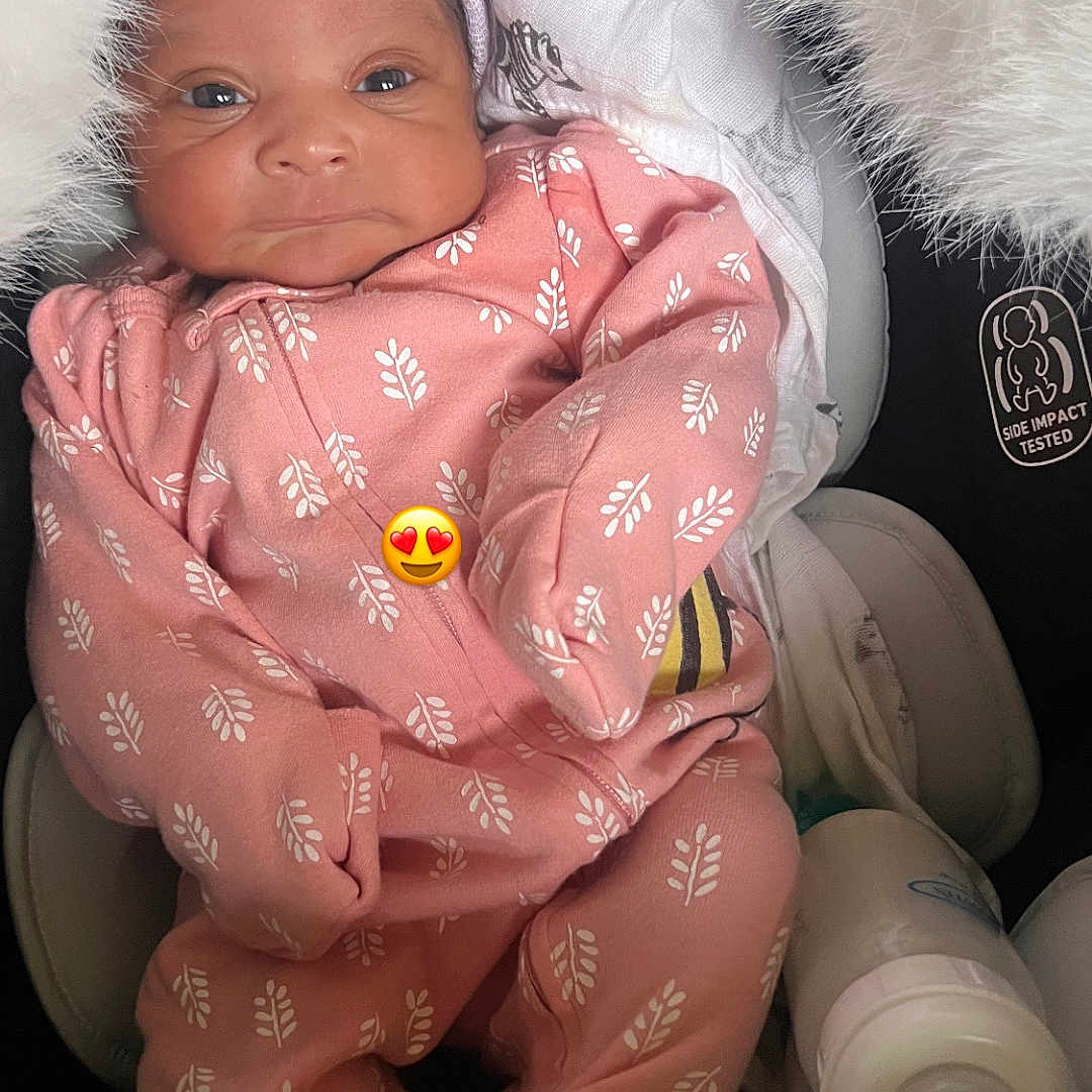 Vanity Marie is registered to the contest to win money with this photo: adorable, baby, baby_bottle, blanket, car_seat, comfort, cozy, cushion, cute, emoji, face, headband, indoors, infant, newborn, person, pink_onesie, resting, sleepwear, soft