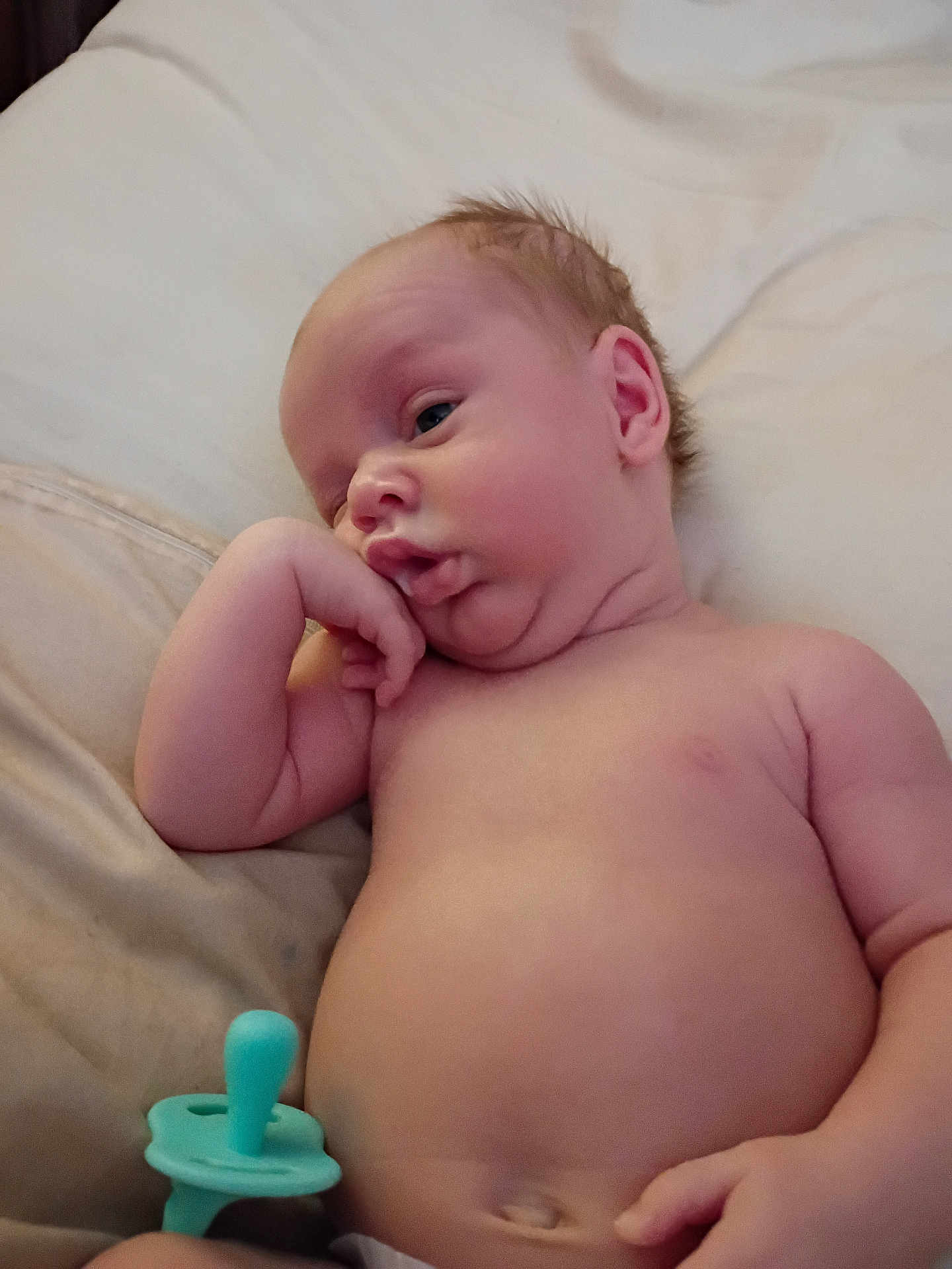 Nash joined the competition — help win amazing prizes! baby, infant, pacifier, skin, hand, face, expression, lying_down, soft_surface, newborn, cute, chubby, portrait, resting, child, human, young, indoors, relaxed, peaceful