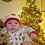 Tom a rejoint le concours — aidez-le/la à gagner de superbes lots ! baby, child, christmas_tree, holiday, pajamas, hat, ornaments, lights, festive, indoor, celebration, smile, face, person, hand, cozy, warm, decorations, gift, christmas