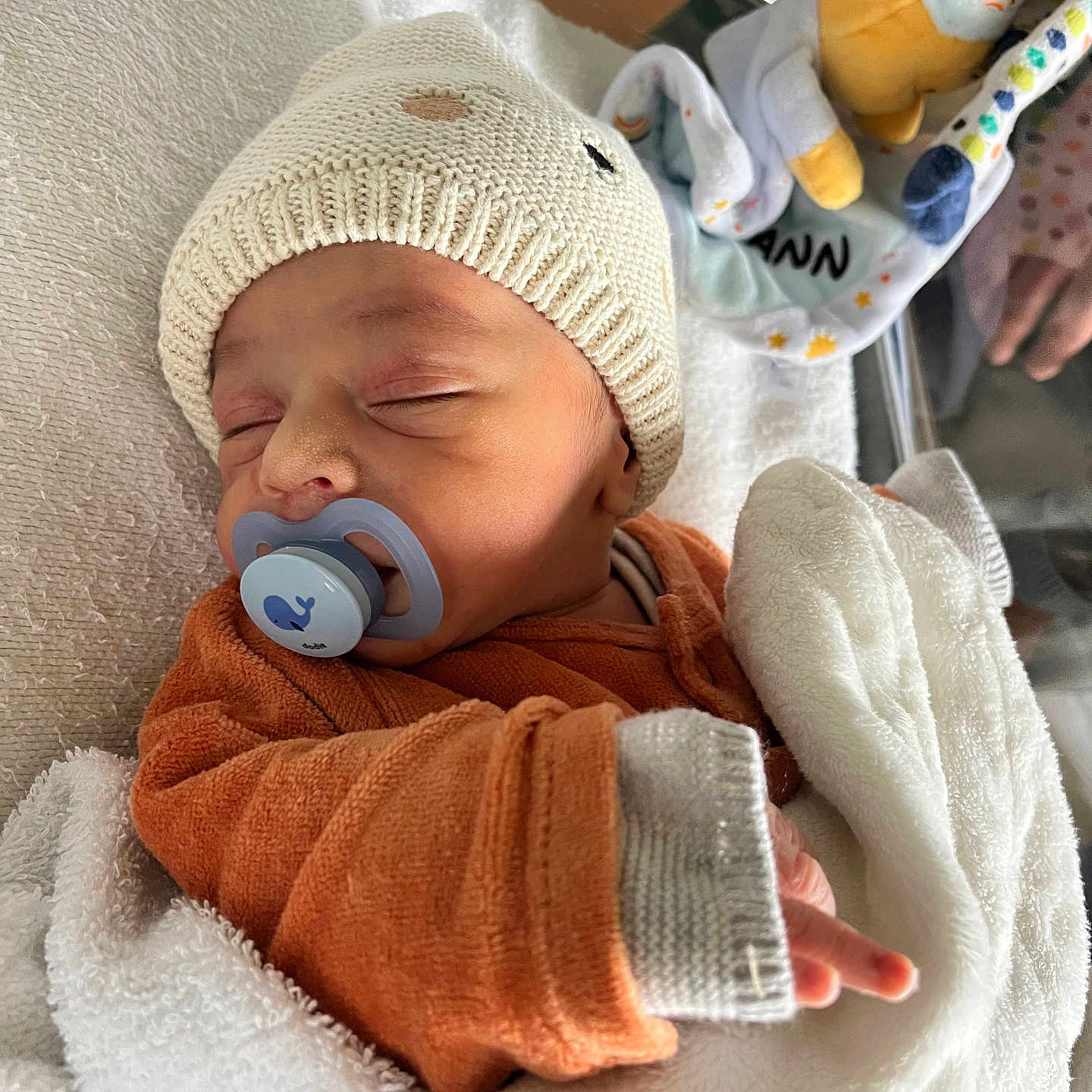 Leyann a rejoint le concours — aidez-le/la à gagner de superbes lots ! baby, bed, blanket, child, cozy, cute, cute_outfit, hand, indoors, infant, knit_hat, newborn, orange_clothing, pacifier, peaceful, person, plush_toy, resting, sleeping, soft_texture