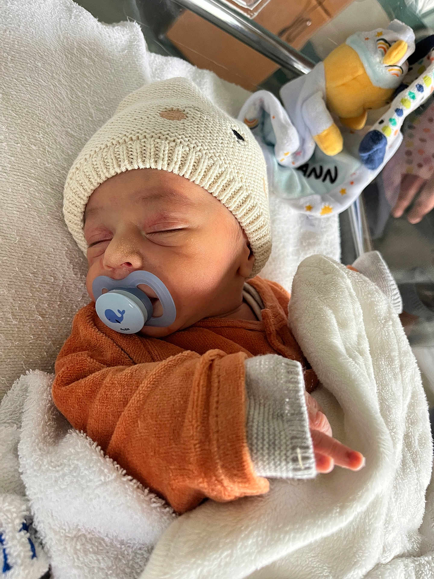 Leyann a rejoint le concours — aidez-le/la à gagner de superbes lots ! baby, bed, blanket, child, cozy, cute, cute_outfit, hand, indoors, infant, knit_hat, newborn, orange_clothing, pacifier, peaceful, person, plush_toy, resting, sleeping, soft_texture