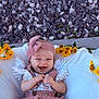 Everleigh is registered to the contest to win money with this photo: baby, infant, smile, headband, flowers, yellow_flowers, blanket, outdoor, rock, concrete, happy, cute, clothing, person, portrait, nature, baby_girl, sitting, hands, closeup