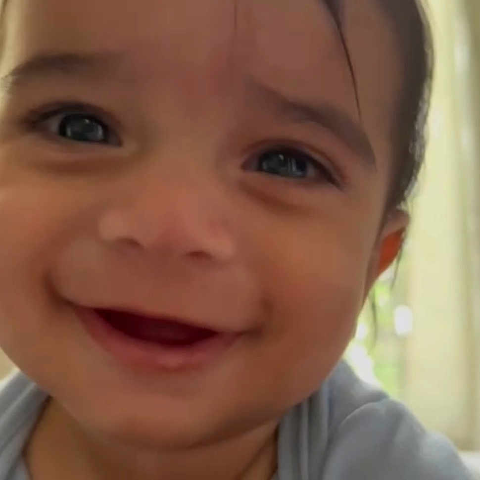 Maël participe au concours pour gagner de l'argent avec cette photo : baby, baby_clothing, background, child, close_up, cute, expression, eyes, face, happy, head, indoors, infant, joy, natural_light, person, portrait, skin, smiling, young