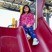 Aryah joined the competition — help win amazing prizes! child, slide, playground, outdoor, jacket, pants, shoes, play_equipment, smiling, happy, person, recreation, fun, daylight, structure, metal, plastic, clothing, activity, young