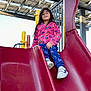 child, slide, playground, outdoor, jacket, pants, shoes, play_equipment, smiling, happy, person, recreation, fun, daylight, structure, metal, plastic, clothing, activity, young