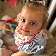 Lila a rejoint le concours — aidez-le/la à gagner de superbes lots ! toddler, baby, child, smiling, blue_eyes, bib, striped_clothing, crib, toy, soft_toy, indoor, cute, person, portrait, happy, infant, closeup, playtime, baby_girl, looking_up