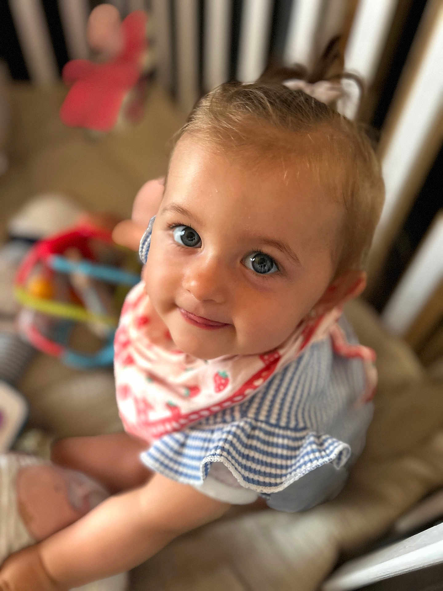 Lila a rejoint le concours — aidez-le/la à gagner de superbes lots ! toddler, baby, child, smiling, blue_eyes, bib, striped_clothing, crib, toy, soft_toy, indoor, cute, person, portrait, happy, infant, closeup, playtime, baby_girl, looking_up