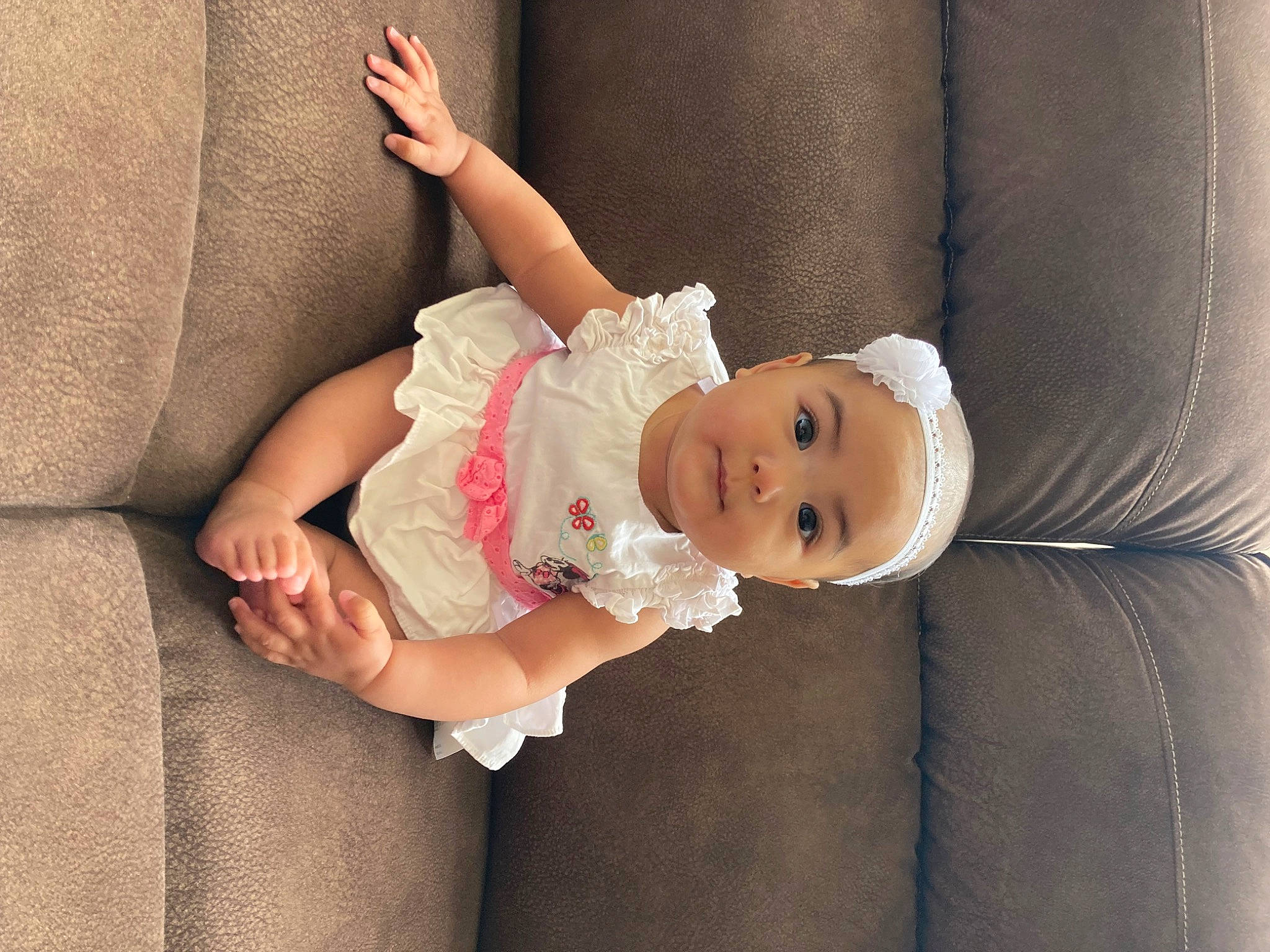 Lexie is registered to the contest to win money with this photo: baby, baby_toddler_clothing, child, comfort, couch, dress, flash_photography, happy, human_body, human_leg, linens, pattern, person, sitting, skin, sleeve, smile, thigh, toddler, wood