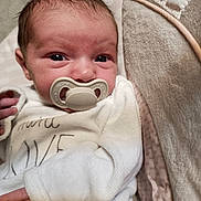 Lily-Rose a rejoint le concours — aidez-le/la à gagner de superbes lots ! newborn, baby, pacifier, infant, white_clothing, blanket, cushion, face, hand, cozy, sleepwear, portrait, closeup, skin, soft_texture, indoor, resting, cute, child, person