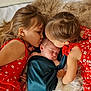 baby, child, children, sleeping, kissing, red_dress, floral_pattern, blanket, fur_rug, siblings, cute, peaceful, indoor, family, portrait, infant, toddler, love, affection, cozy