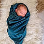 newborn, baby, sleeping, swaddled, blanket, blue, fur_rug, soft_texture, peaceful, infant, portrait, cozy, cute, resting, wrapped, head, face, skin, closeup, indoors