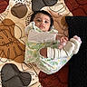 baby, blanket, child, colorful, comfort, cozy, curious, cute, floral_clothing, indoor, infant, lying_down, patterned, person, playful, portrait, quilt, socks, soft_toys, textile