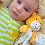 baby, infant, plush_toy, giraffe, blanket, teddy_bear_pattern, striped_clothing, onesie, yellow, green, blue, soft_texture, face, eyes, cute, lying_down, comfort, infant_clothing, baby_bedding, portrait