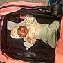Kemani is registered to the contest to win money with this photo: baby, infant, stroller, blanket, hat, clothing, floor, wood_floor, person, child, cute, indoors, portrait, newborn, soft, pattern, pink, black, white, gaze