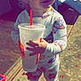 Makayla is registered to the contest to win money with this photo: toddler, child, pajamas, slippers, cup, burger_king, indoor, carpet, floor, person, standing, smiling, curly_hair, toy, furniture, home, cozy, drink, cute, playful