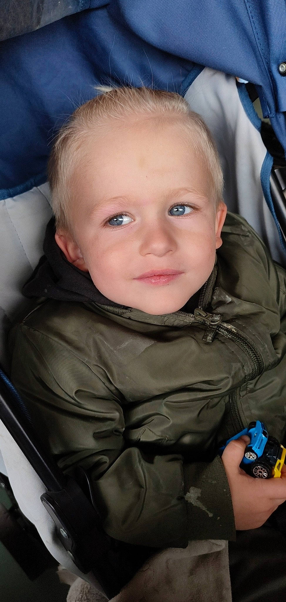 Sloan a rejoint le concours — aidez-le/la à gagner de superbes lots ! baby_carriage, blue, car_seat, cheek, comfort, cool, eye, eyebrow, face, facial_expression, finger, forehead, head, iris, mouth, nose, person, product, skin, smile