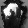cat, mirror, reflection, black_and_white, indoor, ornate_frame, silhouette, furniture, room, window, soft_focus, shadow, vintage, decor, animal, pet, still_life, contrast, quiet, mysterious