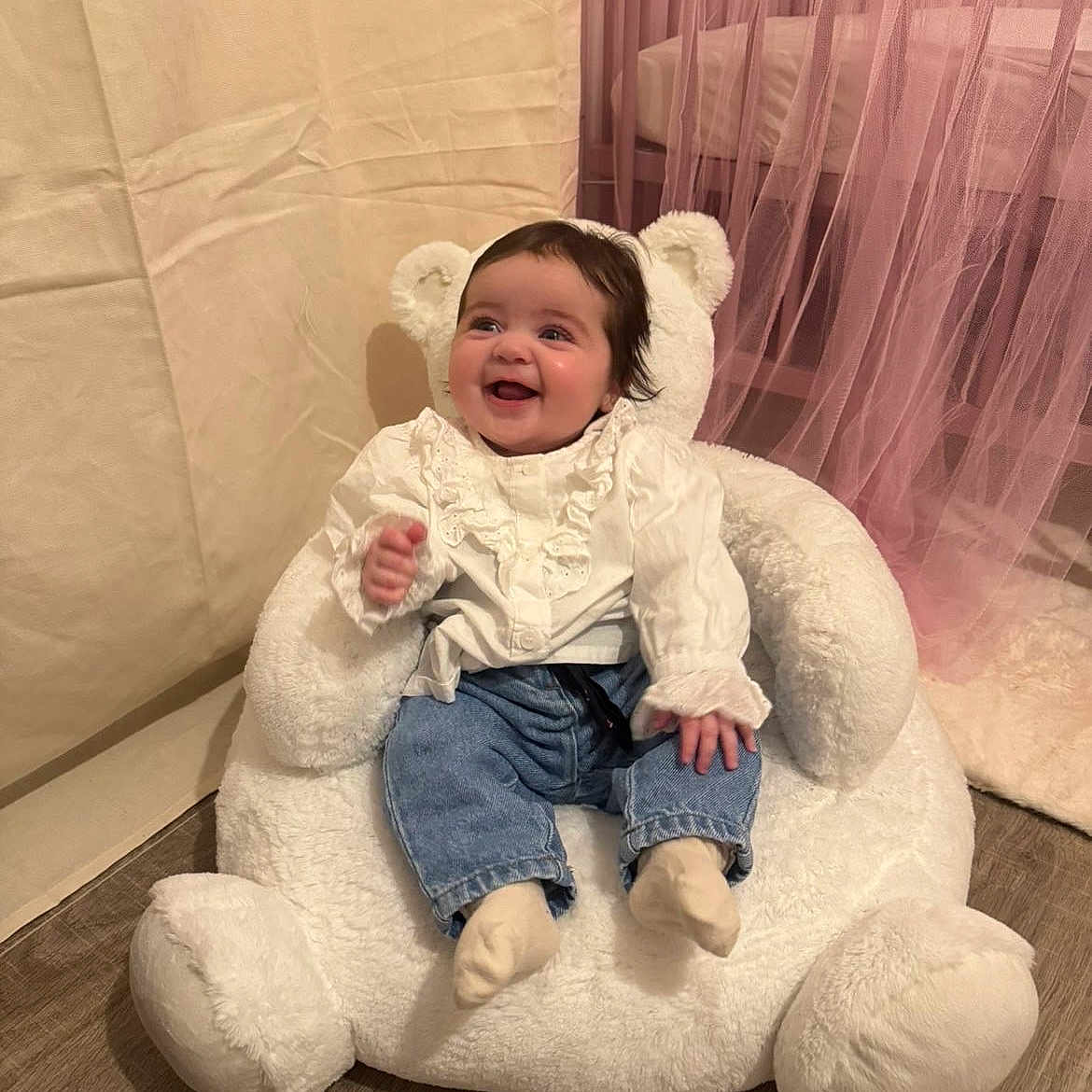 Lyana a rejoint le concours — aidez-le/la à gagner de superbes lots ! baby, child, cozy, curtains, cute, flooring, furniture, happy, home_interior, indoor, infant, jeans, pink, portrait, seated, smiling, socks, soft_toys, teddy_bear_chair, white_clothing