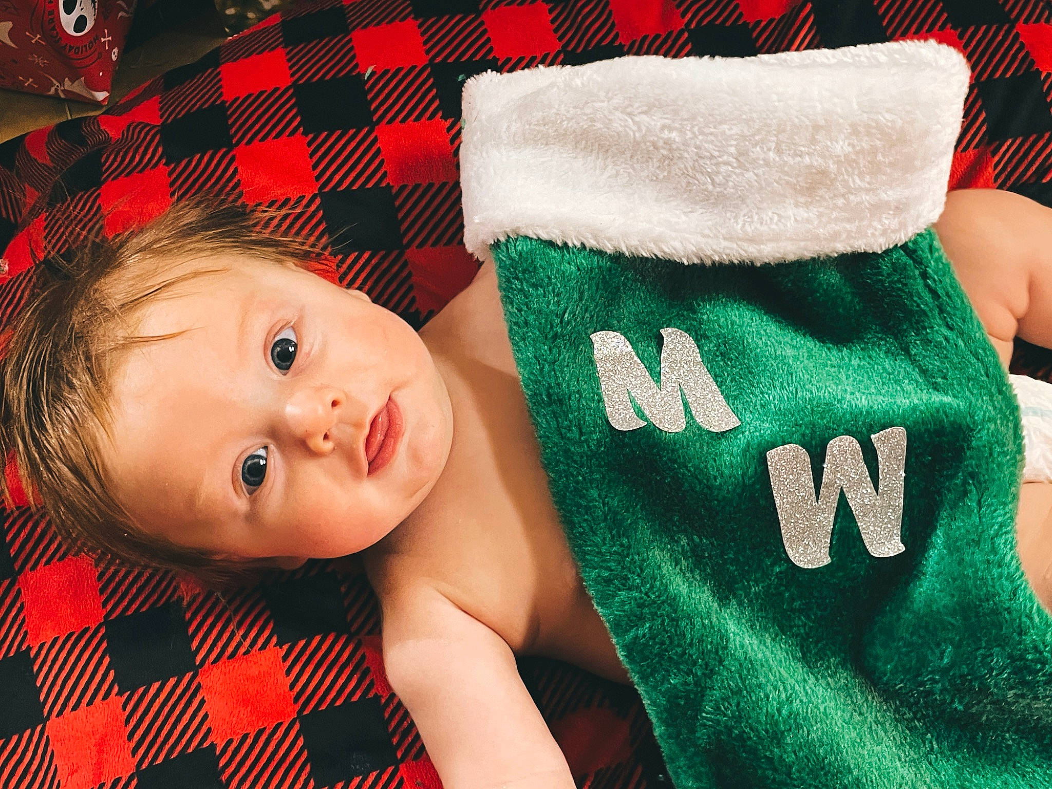Maverick is registered to the contest to win money with this photo: baby, baby_toddler_clothing, comfort, eye, finger, glove, grass, happy, holiday, human_body, linens, mammal, pattern, person, plaid, product, sleeve, sock, textile, toddler