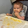 Sirena joined the competition — help win amazing prizes! baby, child, high_chair, messy, food, eating, face, hand, table, indoor, feeding, meal, cute, toddler, expression, clothing, seat, infant, smile, yellow_food