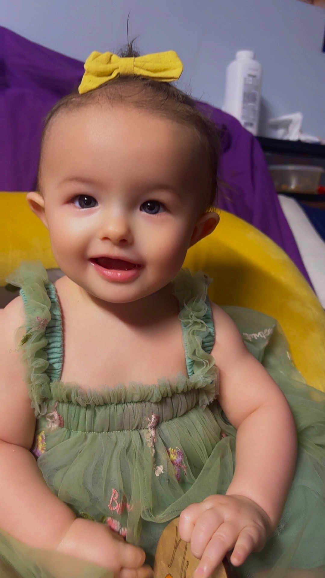 Sirena joined the competition — help win amazing prizes! baby, bottle, child, cushion, cute, ears, eyes, green_dress, hair_bow, hands, indoor, portrait, purple_blanket, smile, soft_lighting, teeth, toddler, tulle, wooden_toy, yellow_bow