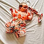 Judith participe au concours pour gagner de l'argent avec cette photo : baby, infant, child, floral_clothing, orange_shirt, lying_down, blanket, cute, small_hands, soft_texture, head, face, newborn, infant_fashion, portrait, indoors, light, expression, baby_girl, comfort