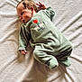 baby, baby_garment, blanket, child, cute, face, footed_pajamas, green_clothing, head, indoor, infant, lying_down, newborn, onesie, peaceful, portrait, resting, sleepwear, small_hands, soft_texture