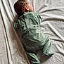 baby, blanket, child, cozy, cute, fabric, footed_pajamas, green_clothing, head, indoors, infant, lying_down, newborn, onesie, peaceful, portrait, resting, sleeping, soft_texture, toddler