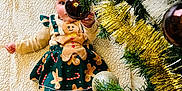 Judith a rejoint le concours — aidez-le/la à gagner de superbes lots ! baby, barefoot, blanket, celebration, child, christmas_tree, cute, dress, festive, gingerbread, gold_baubles, greenery, holiday, holiday_decor, indoors, infant, ornament, playful, smiling, tinsel