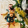 baby, barefoot, blanket, celebration, child, christmas_tree, cute, dress, festive, gingerbread, gold_baubles, greenery, holiday, holiday_decor, indoors, infant, ornament, playful, smiling, tinsel