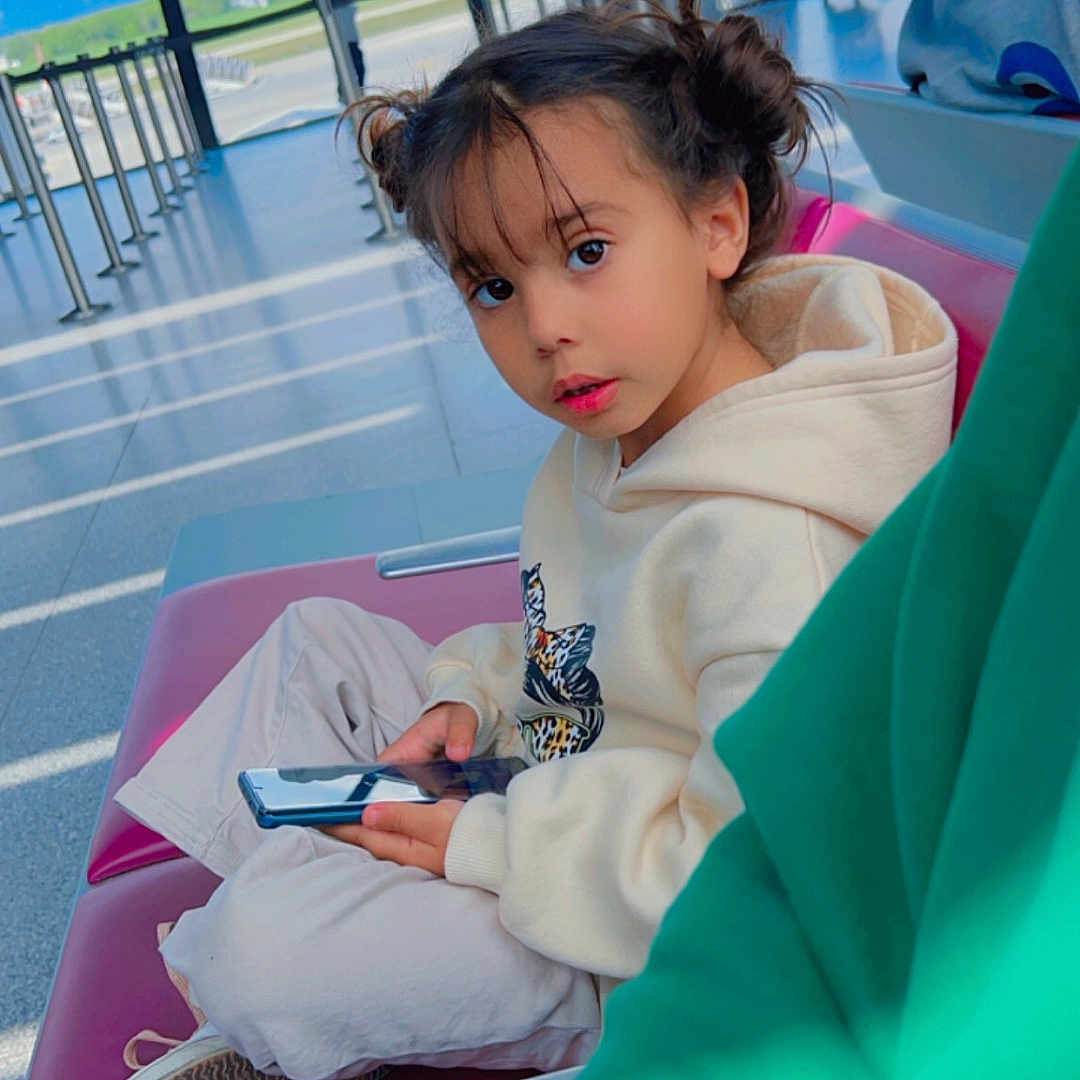Louna participe au concours pour gagner de l'argent avec cette photo : architecture, building, child, clothing, electronics, face, female, footwear, furniture, girl, head, mobilephone, outdoors, person, phone, photography, portrait, shelter, shoe, sitting