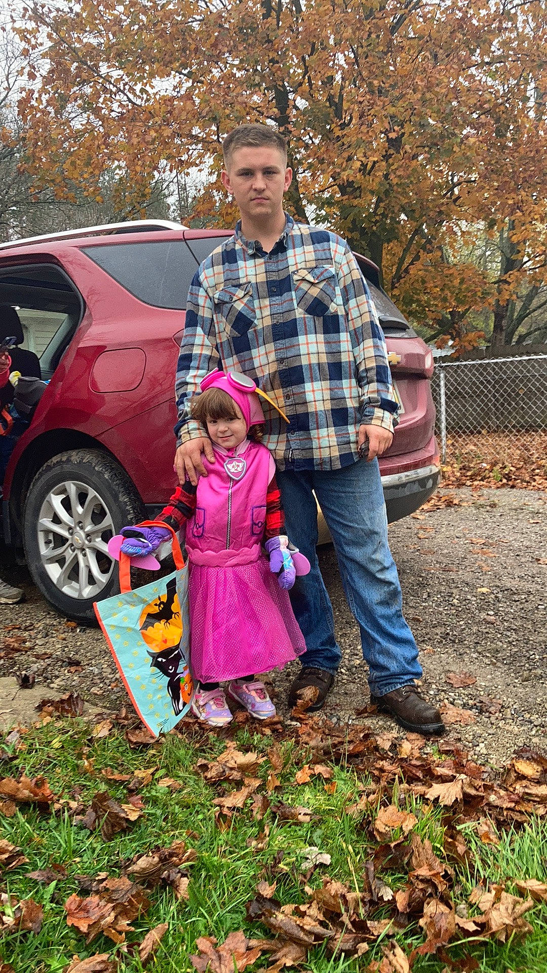 Amelia is registered to the contest to win money with this photo: automotive_exterior, car, event, fun, grass, joy, land_vehicle, leaf, leisure, motor_vehicle, person, plaid, plant, recreation, tartan, tire, toddler, tree, vehicle, vehicle_door