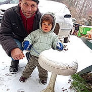 Léo participe au concours pour gagner de l'argent avec cette photo : adult, car, child, clothing, cold, footwear, grass, hood, jacket, man, mittens, nature, outdoor, people, portrait, snow, stool, toddler, trees, winter