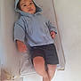 Léo a rejoint le concours — aidez-le/la à gagner de superbes lots ! baby, blue_clothing, casual_clothing, changing_pad, child, curious, expression, face, feet, hand, hoodie, indoor, lying_down, person, relaxed, shorts, skin, toddler, young, young_child