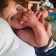 Léo participe au concours pour gagner de l'argent avec cette photo : baby, casual, child, close_up, comfort, couch, curly_hair, cute, eating, face, hand, indoor, infant, person, portrait, relaxed, resting, skin, snack, young