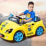 Aaron is registered to the contest to win money with this photo: child, boy, toy_car, yellow_car, minion_stickers, blue_wheels, blue_shirt, short_hair, indoor, playing, smiling, steering_wheel, seat, floor, plastic_toy, vehicle, portrait, fun, kid, happy