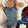 baby, baby_clothing, blanket, blue_romper, child, cozy, cute, happy, indoor, infant, lying_down, paper_airplane_pattern, portrait, raised_arm, smiling, soft_texture, spiderman, superhero, two_months, wooden_sign