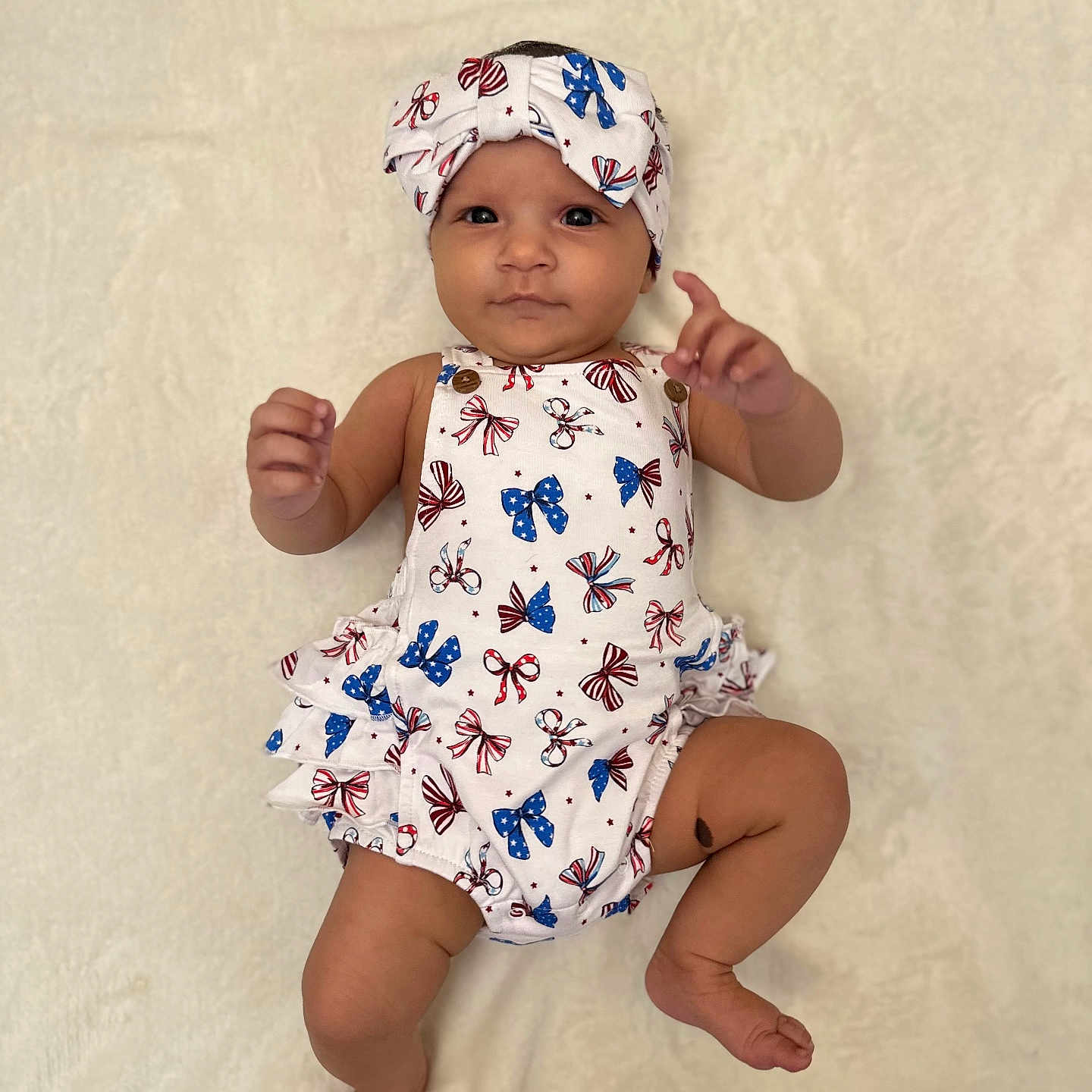 Malia Rose joined the competition — help win amazing prizes! adorable, baby, child, closeup, cute, feet, headband, indoor, infant, legs, lying_down, patterned_clothing, person, portrait, raising_hand, romper, skin, smiling, soft_blanket, white_background