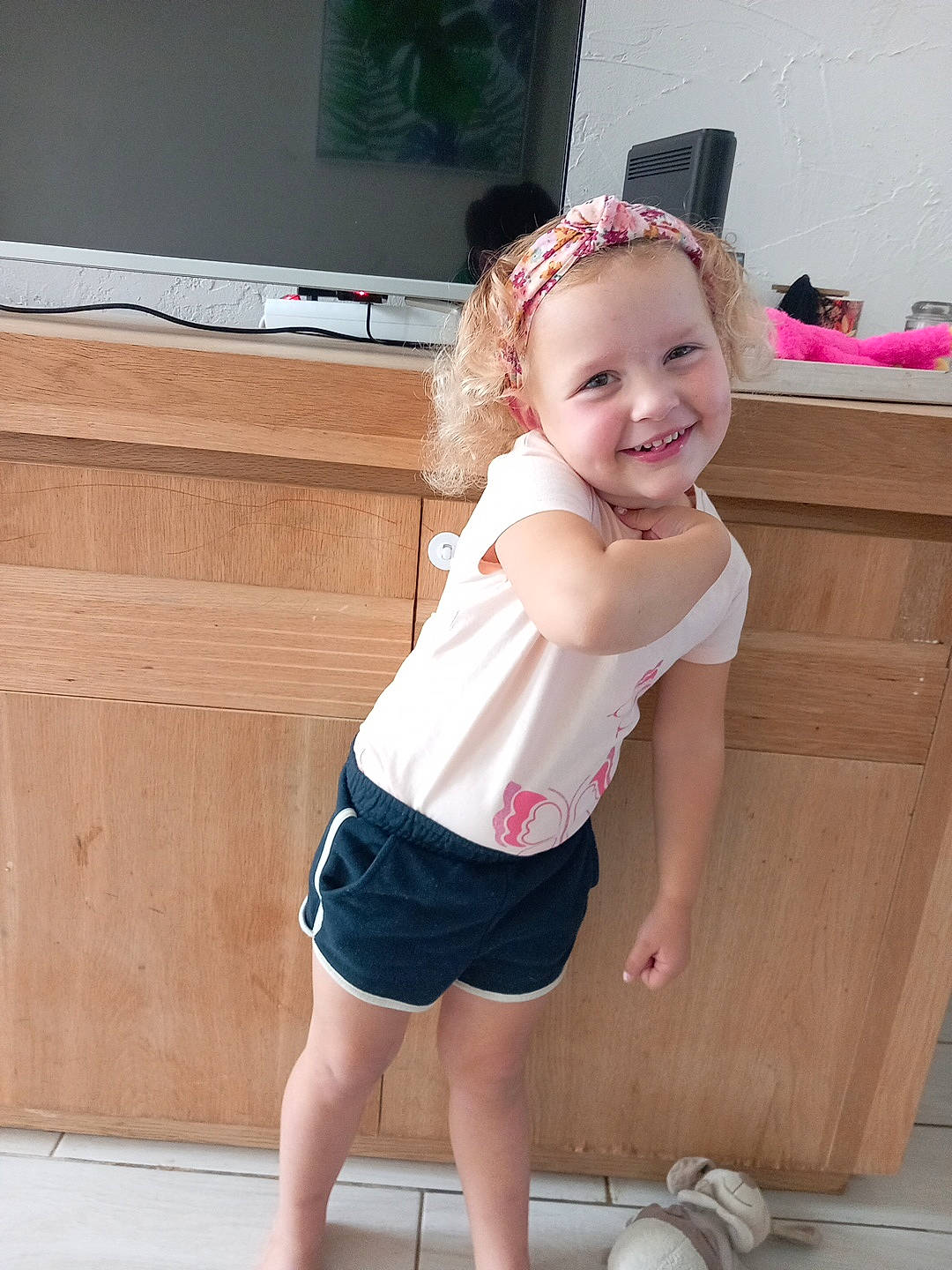 Léa participe au concours pour gagner de l'argent avec cette photo : baby_toddler_clothing, child, eye, face, facial_expression, happy, head, human_leg, joint, joy, knee, leg, person, pink, shorts, skin, smile, standing, television, thigh