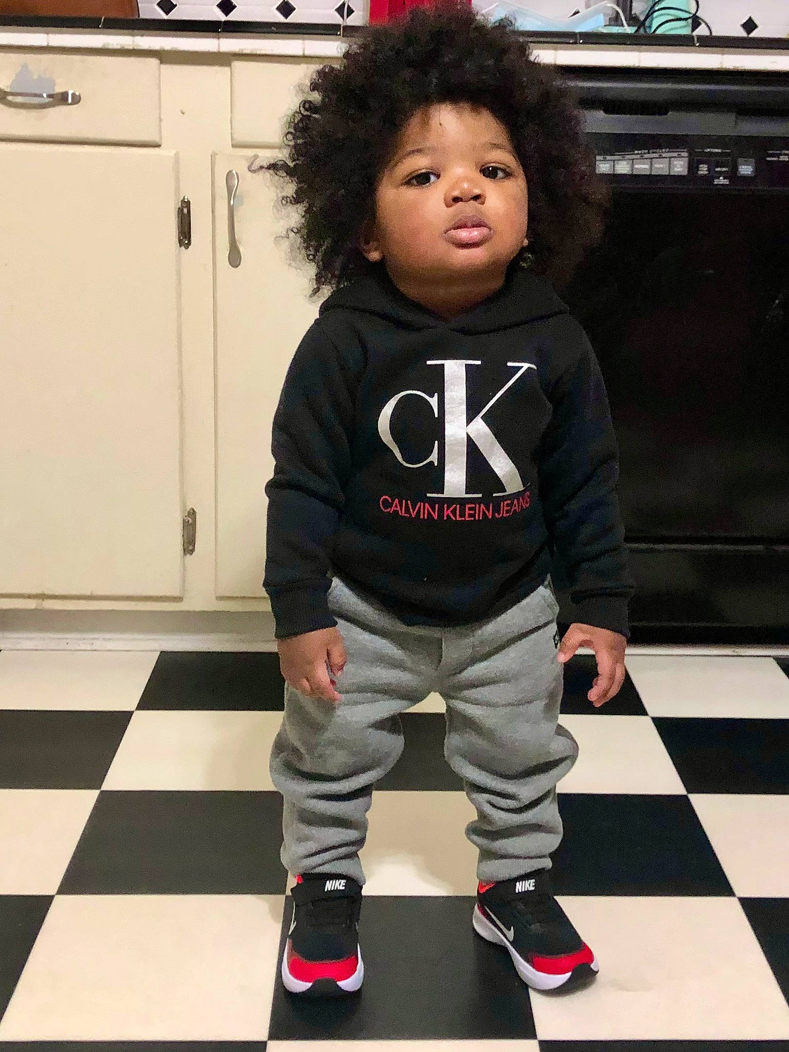 Creed is registered to the contest to win money with this photo: beauty, black, cool, fashion_design, floor, flooring, fun, hairstyle, joint, knee, person, shoe, sleeve, snapshot, sneakers, sportswear, standing, street_fashion, thigh, toddler