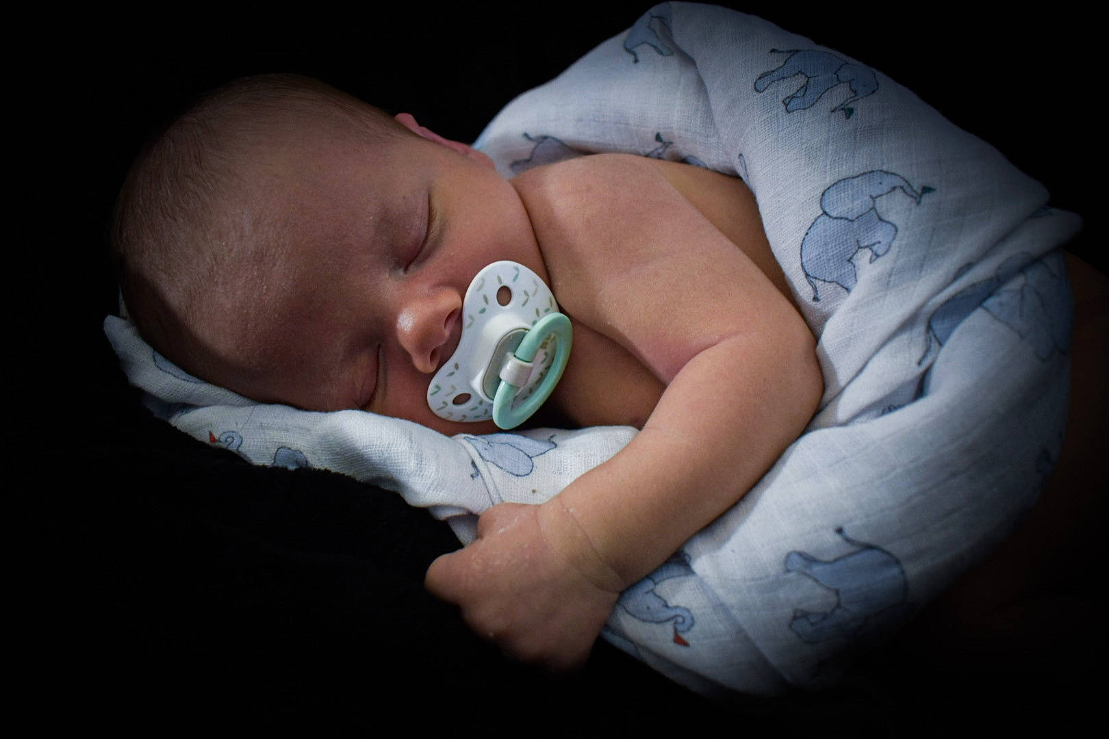 Ozzy is registered to the contest to win money with this photo: baby, baby_products, baby_sleeping, baby_toddler_clothing, cheek, child, comfort, darkness, ear, finger, flash_photography, gesture, health_care, human, linens, mouth, neck, nose, person, skin