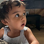 Miriam is registered to the contest to win money with this photo: toddler, child, indoor, portrait, curious, messy_hair, topknot, blue_dress, skin, face, hand, expression, person, baby, young_child, furniture, blurred_background, natural_light, cute, casual