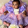 baby, child, dress, purple, pink, flowers, flower_arrangement, portrait, cute, infant, sitting, decorative, costume, puffy_sleeves, soft_lighting, studio_photo, young_child, pretty, adorable, floral_background