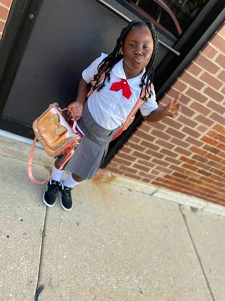 Kenyla Douglas joined the competition — help win amazing prizes! asphalt, automotive_tire, bag, bumper, city, concrete, eyewear, fun, leisure, luggage_and_bags, person, recreation, road, road_surface, sidewalk, sitting, smile, street, street_fashion, t_shirt