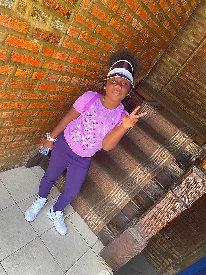 Kenyla Douglas joined the competition — help win amazing prizes! baseball_cap, brick, cap, electric_blue, eyewear, flash_photography, headwear, human_leg, leisure, magenta, pattern, person, pink, purple, sandal, sleeve, sportswear, street_fashion, t_shirt, thigh