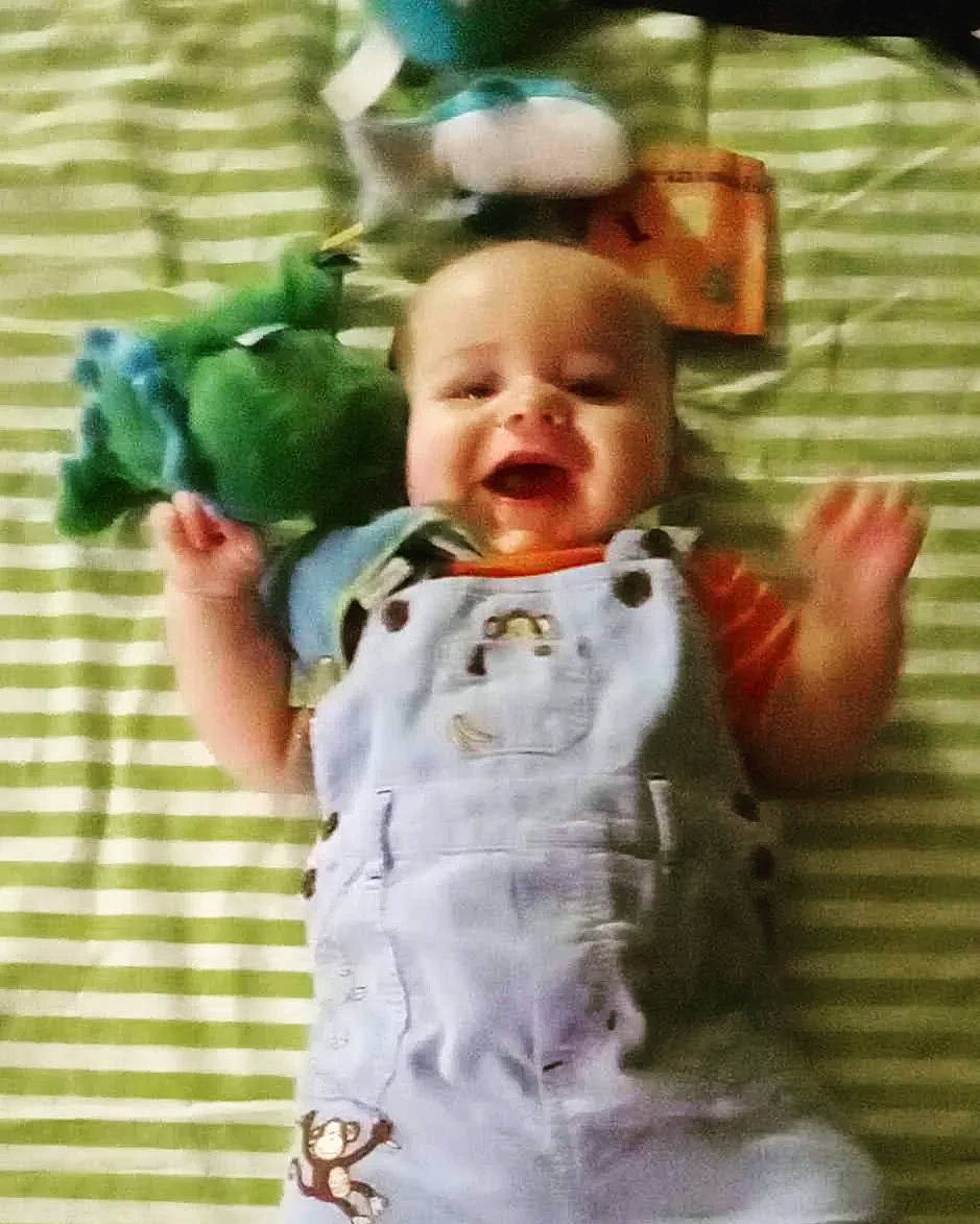 Nathaniel is registered to the contest to win money with this photo: baby, baby_laughing, baby_products, baby_toddler_clothing, baby_toys, cheek, child, eye, green, happy, linens, pattern, person, product, room, sitting, sleeve, smile, t_shirt, textile