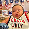 baby, infant, patriotic, fourth_of_july, american_flag, bib, tongue_out, celebration, holiday, festive, red, white, blue, lights, decorations, cute, portrait, smiling, indoor, person