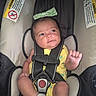 Victoria is registered to the contest to win money with this photo: baby, infant, car_seat, safety_harness, yellow_clothing, bow, headwear, striped_socks, cute, child, seat, restraint, infant_car_seat, person, portrait, indoors, warning_label, black_straps, soft_fabric, baby_girl