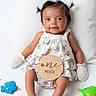 baby, infant, one_month, smiling, pigtails, bow, mittens, floral_dress, sandals, pillow, toys, starfish, fish_toy, green_toy, white_background, cute, portrait, child, lying_down, happy